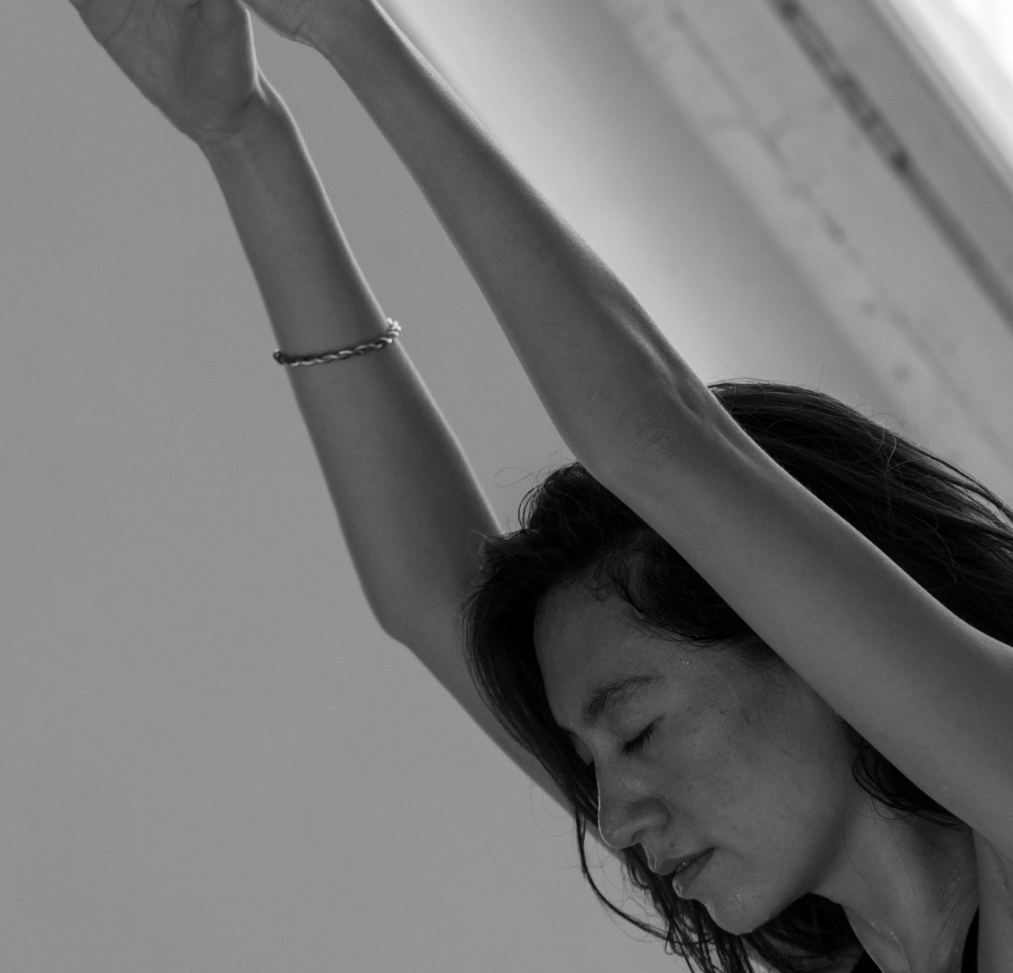 Dancer on the studio floor, arm extended across the wood